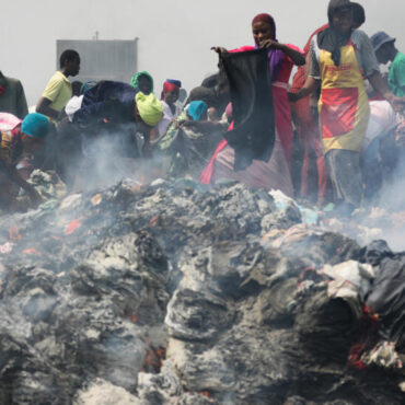 People try to salvage items from the burned down secondhand clothing market at Kantamanto in Accra, Ghana, on January 2, 2025. The fire at the Kantamanto market began in the early morning hours, destroying a large part of the area and displacing thousands of traders. AFP - NIPAH DENNIS